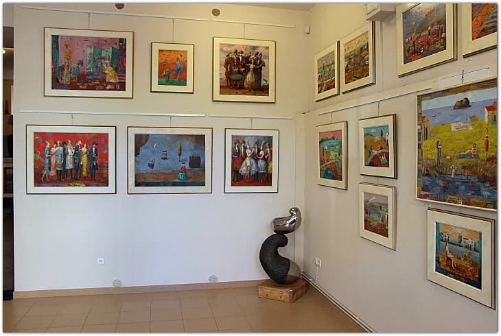 Kolorowe obrazy Jerzego Wojciecha Bieleckiego we wnętrzu galerii