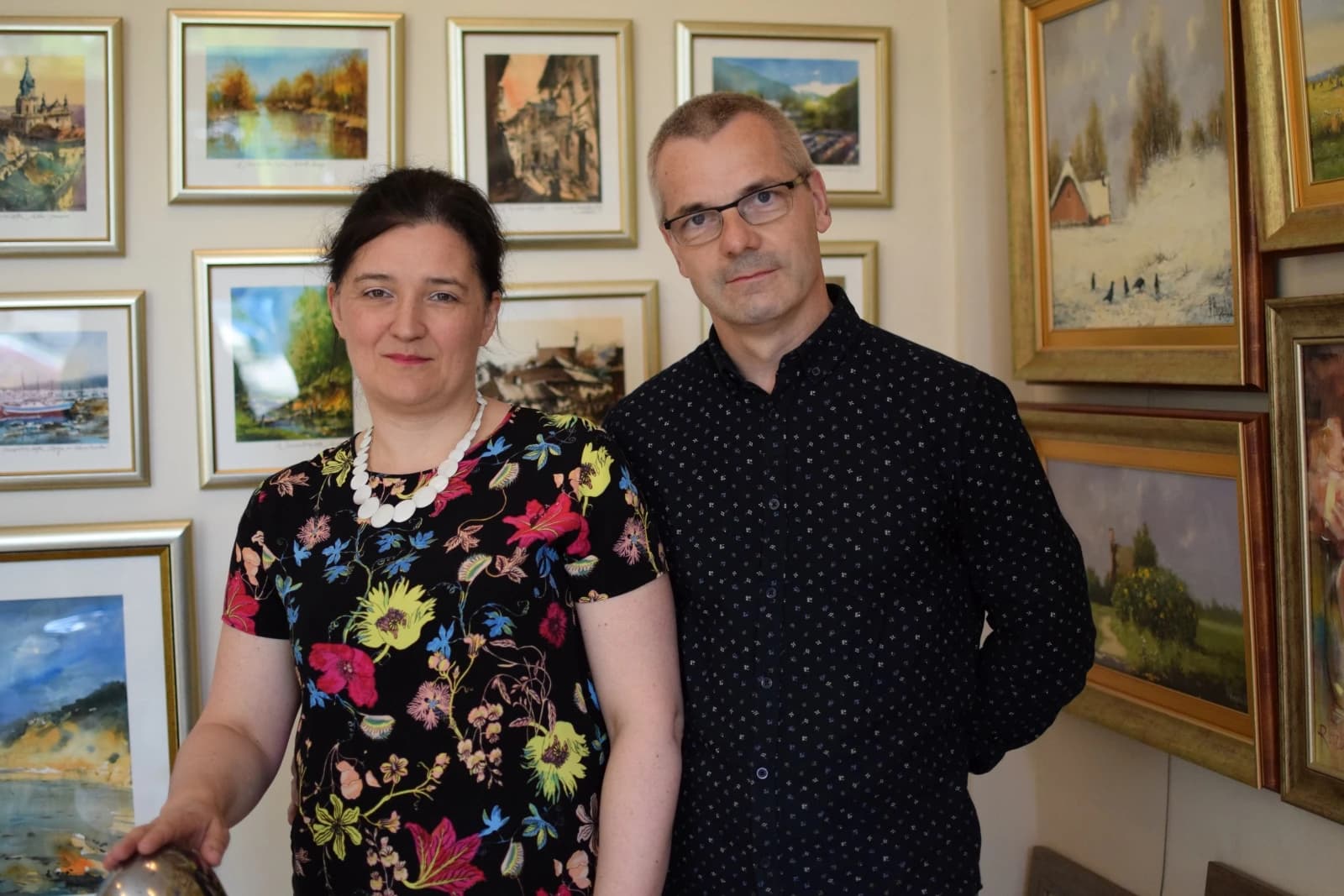 Agnieszka i Artur Kuśnierzowie we wnętrzu Galerii Witryna, na tle prezentowanych obrazów